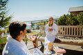 Frau und Mann sitzen auf der sonnigen Terrasse des Mountain Resort Feuerberg und trinken eine Tasse Tee
