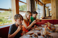 Familie sitzt beim Frühstück des Mountain Resort Feuerberg auf der Gerlitzen Alpe in Kärnten