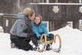Mutter und Sohn im Winter auf einer Rodel im Chaletdorf des Mountain Resort Feuerberg in Kärnten